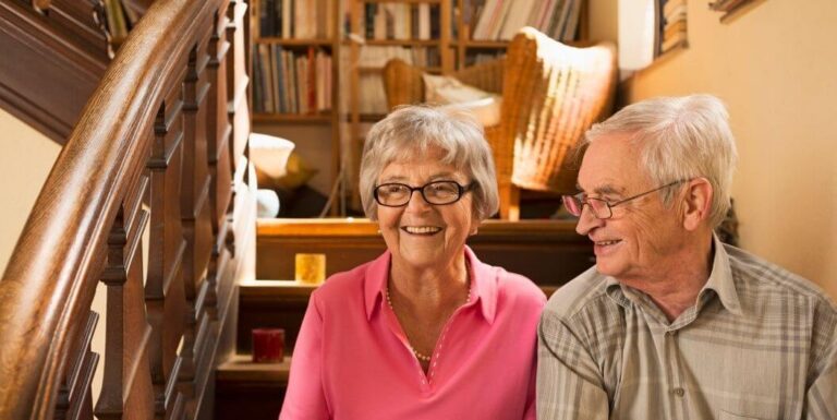 Elderly Couple Reading and Smiling Inside Assisted Living Facility Apartment